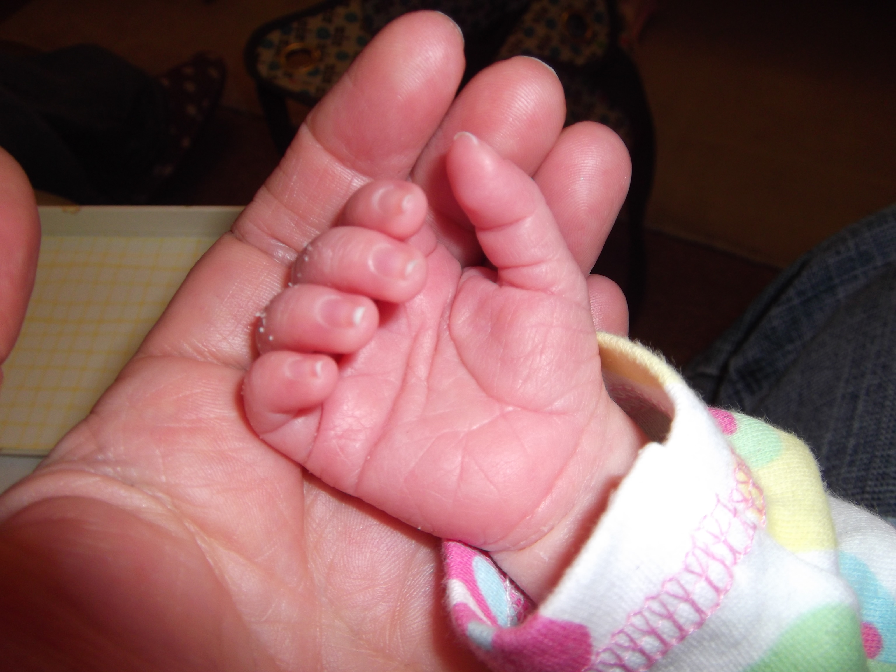 Breastfeeding baby's hand in mine