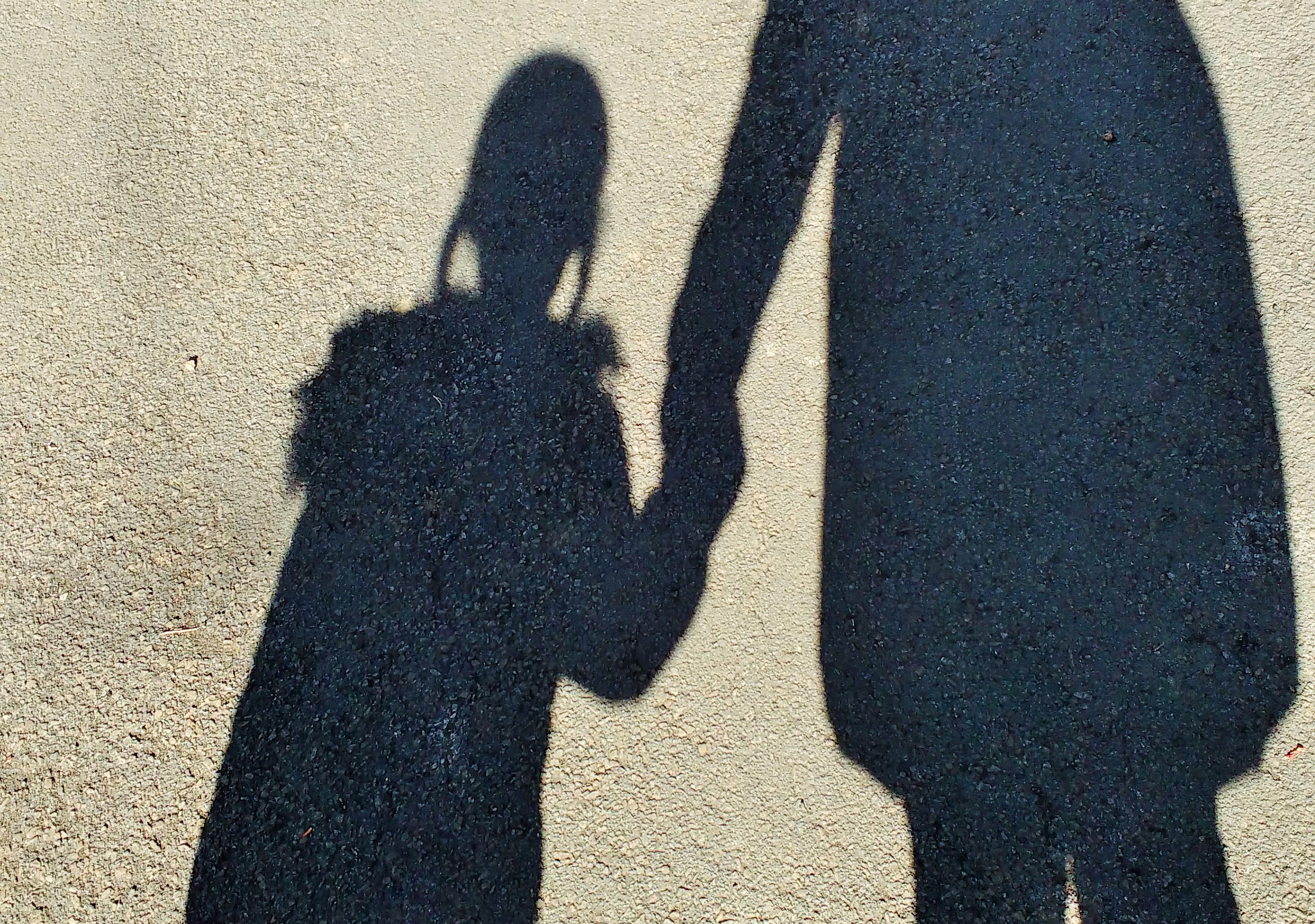 Childhood anxiety - mother and daughter holding hands shadow