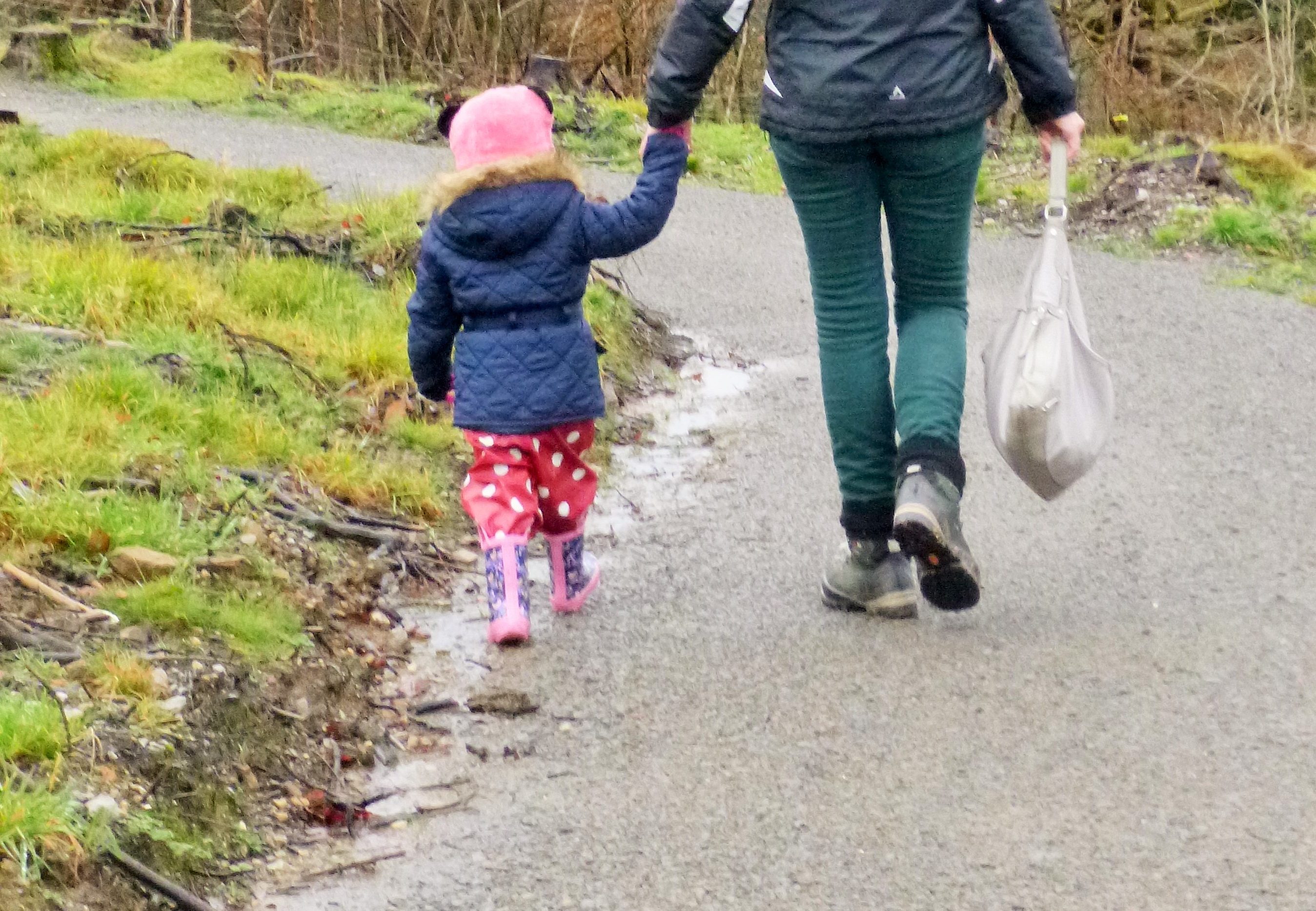 holding hands spotty red trousers muddy stay at home mum and child