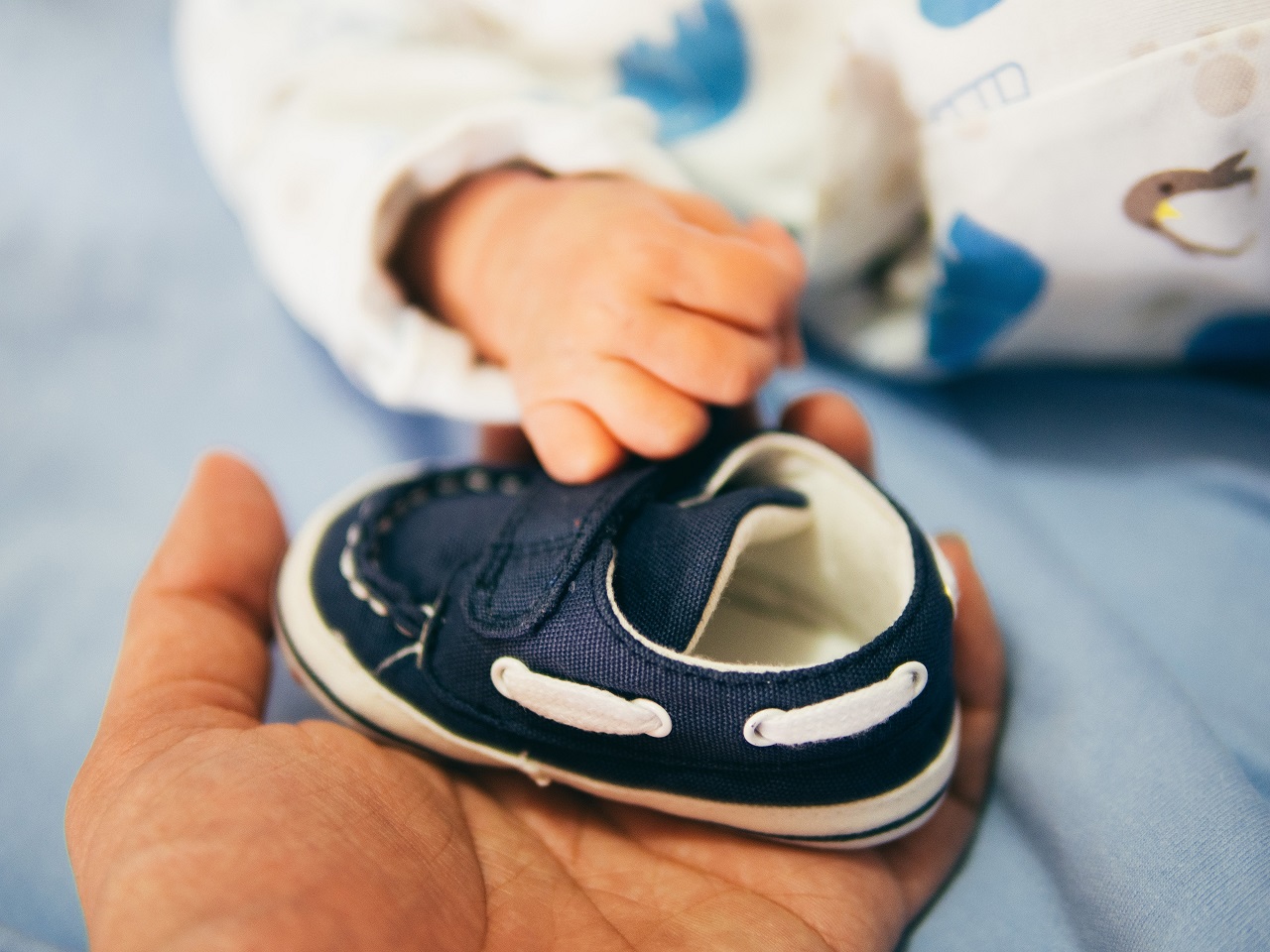 Unexpected pregnancy - baby holding blue baby shoe - photo taken by aditya-romansa