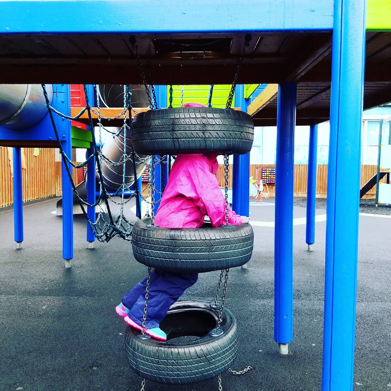 average child - climbing frame at playground tyres