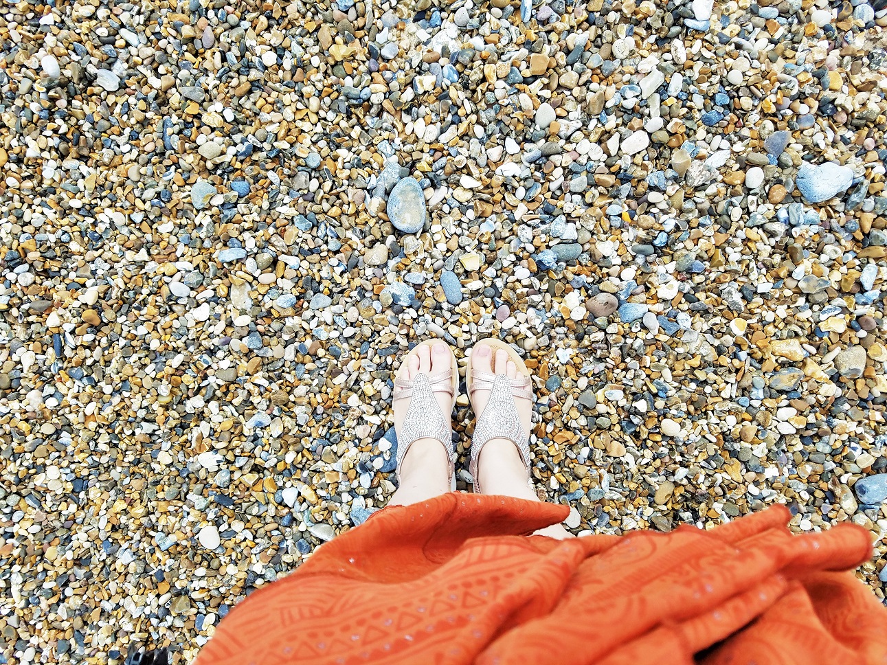Praise inspires children to improve their behaviour - mum with feet on stony beach